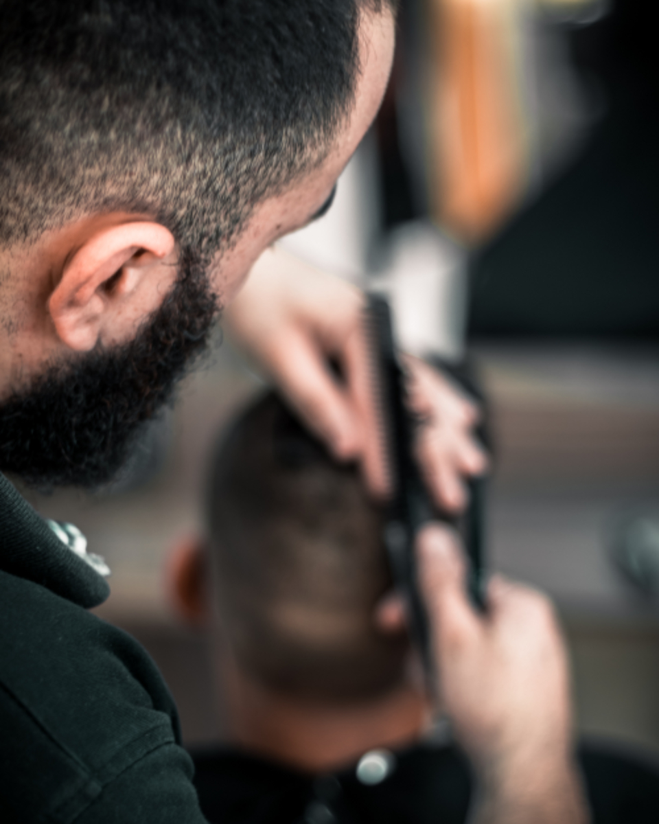 Barbero cortando el pelo a un cliente